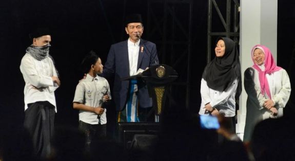 Presiden RI Joko Widodo berdialog dengan para santri saat menghadiri malam puncak peringatan Hari Santri Nusantara, di Lapangan Gasibu, Kota Bandung, Ahad (21/10).